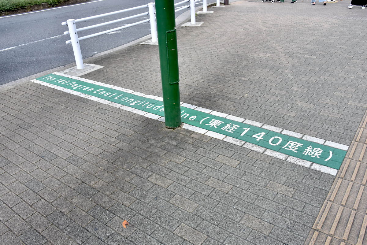 鎌ヶ谷市は東経140度の都市。新鎌ヶ谷駅の駅前広場には、子午線がペイントされている