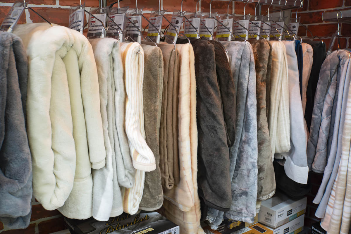 大きさや厚み、質感などを確認・比較できるようにハンガーに下げて展示