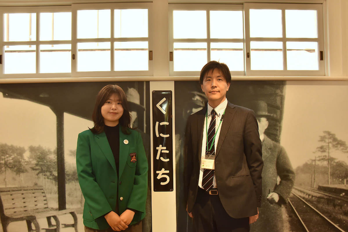 再築された国立駅舎内はタイムスリップしたような雰囲気。藤堂さん(右)と一緒に写るのは、まち案内所スタッフで、国立に立地する一橋大学に通う末武観月さん(左)