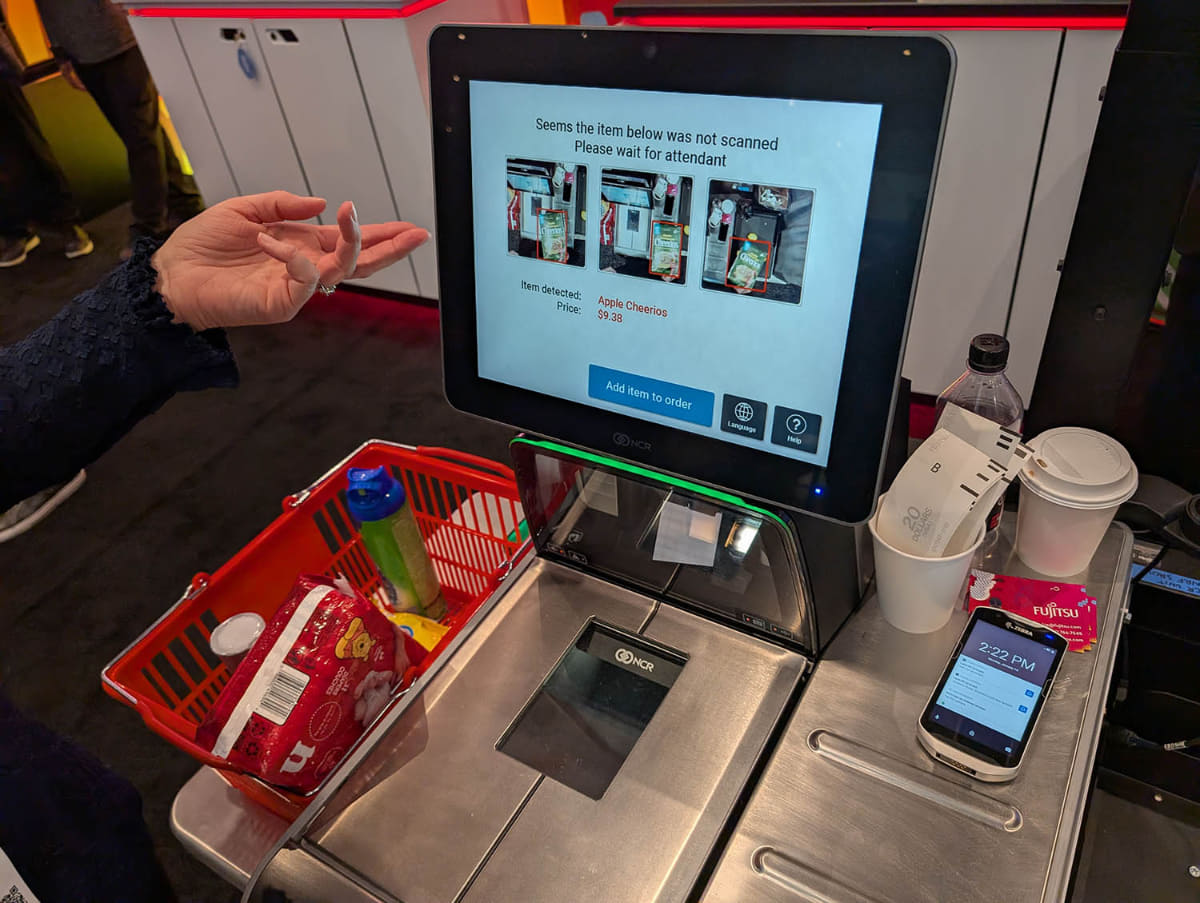 NRF 2025の富士通フロンテックブースにて。セルフレジの不正利用を防ぐソリューションの説明を受ける