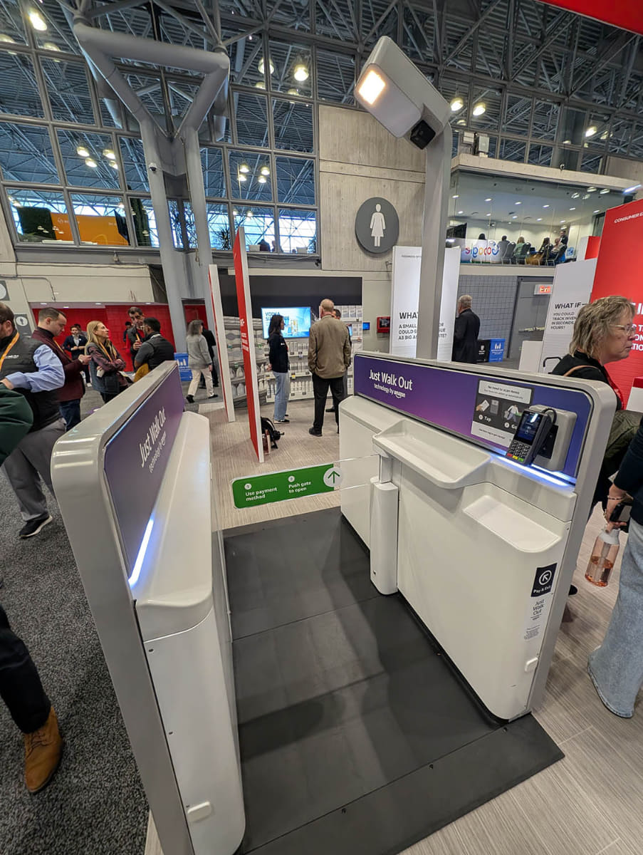 Avery Dennisonのブースに展示されていたAWSのJust Walk Outのデモンストレーション機材。RFIDタグの付いた商品を手にゲートに来るとスキャンが行なわれ合計額が出るので、手元の決済端末で支払うことでゲートが開く。スタジアム等でのグッズ販売などで採用事例が増えているという
