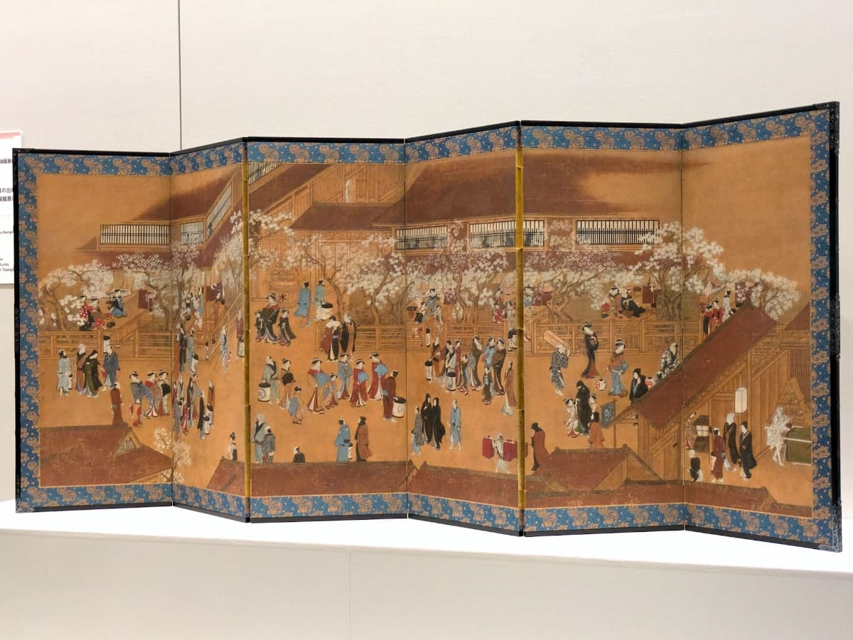 大門を右手に見て、仲之町通りを中心に吉原を俯瞰して描いた、歌川豊春筆の《新吉原春景図屏風》。天明(1781～89)後期～寛政(1789～1801)前期。個人蔵