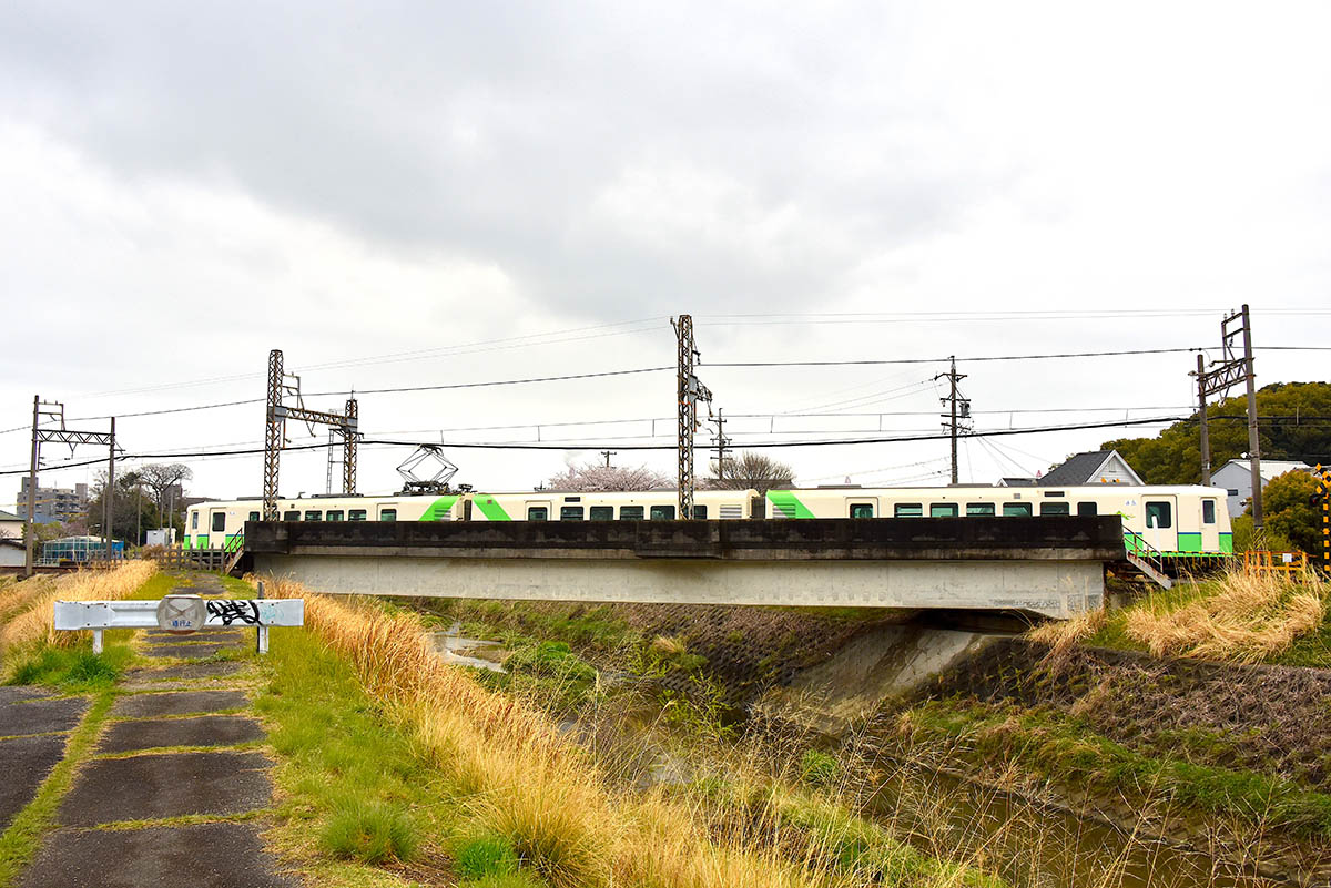 鹿化川の橋梁を渡るあすなろう鉄道の電車