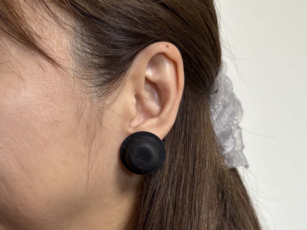 「RelaxQ ほっとイヤリング」SHIROKURO丸型の黒をつけたところ