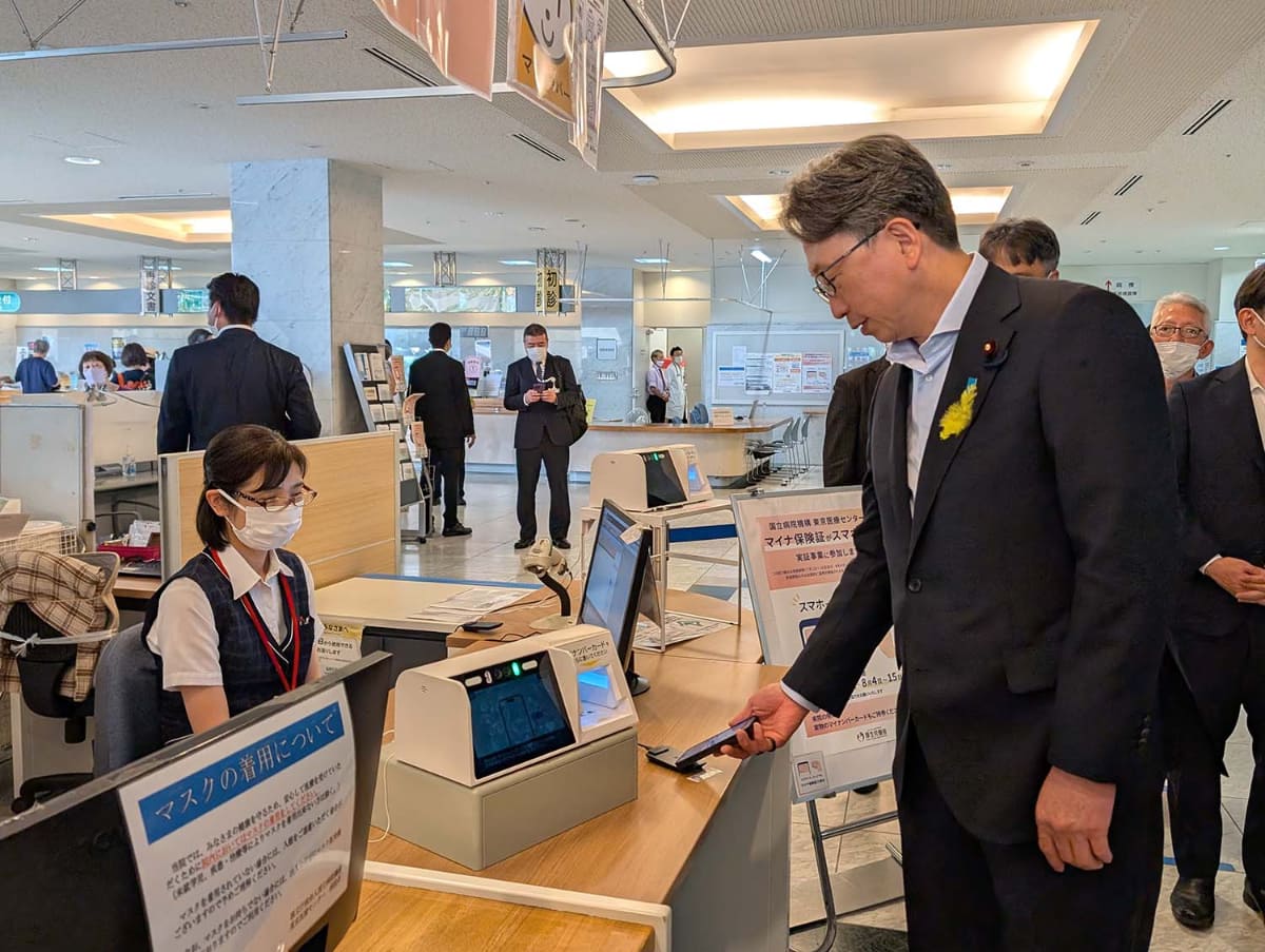 自身のiPhoneでマイナ保険証による受付体験をする平デジタル大臣