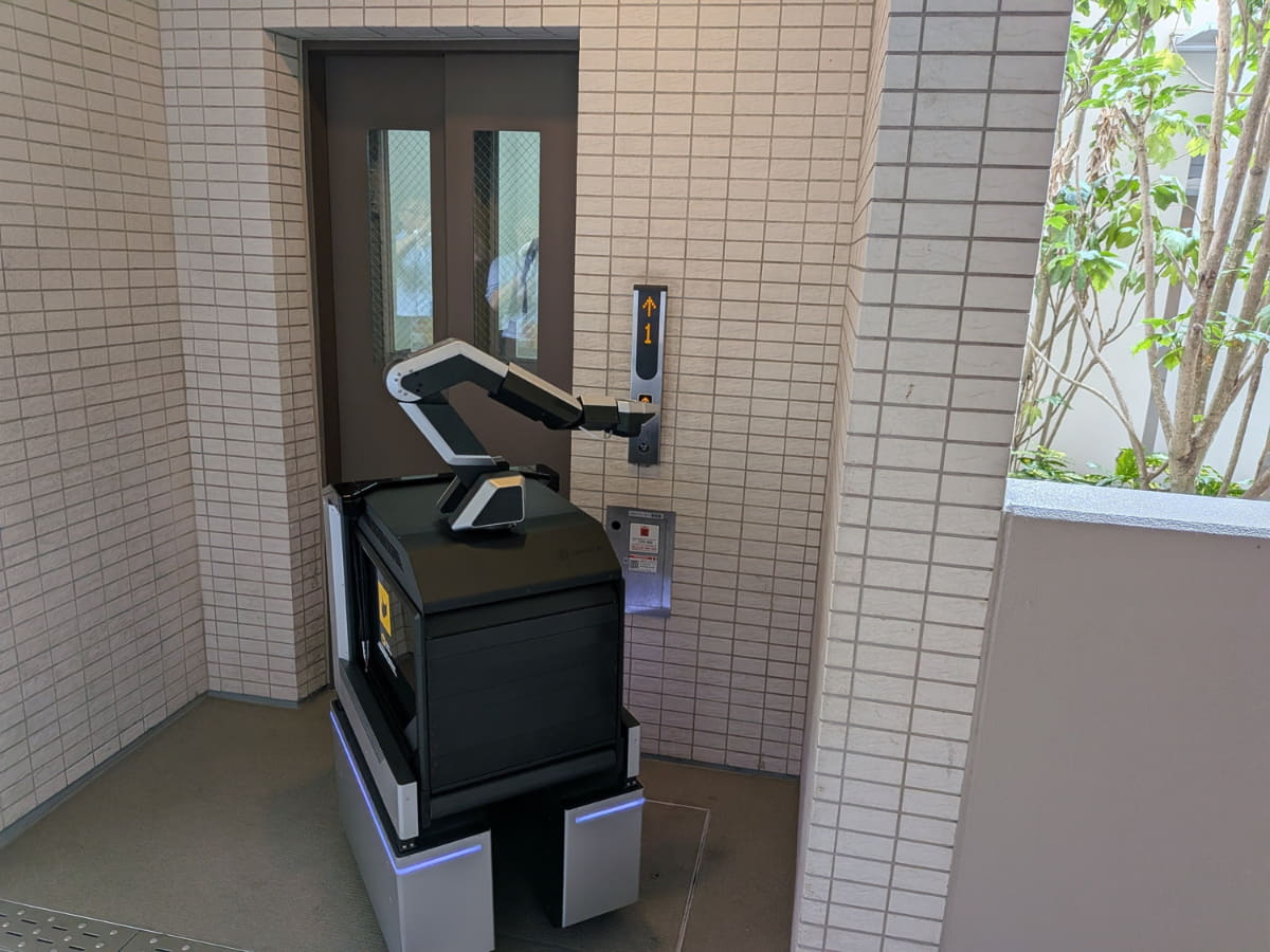 エレベーターのボタンを押して乗り込む様子