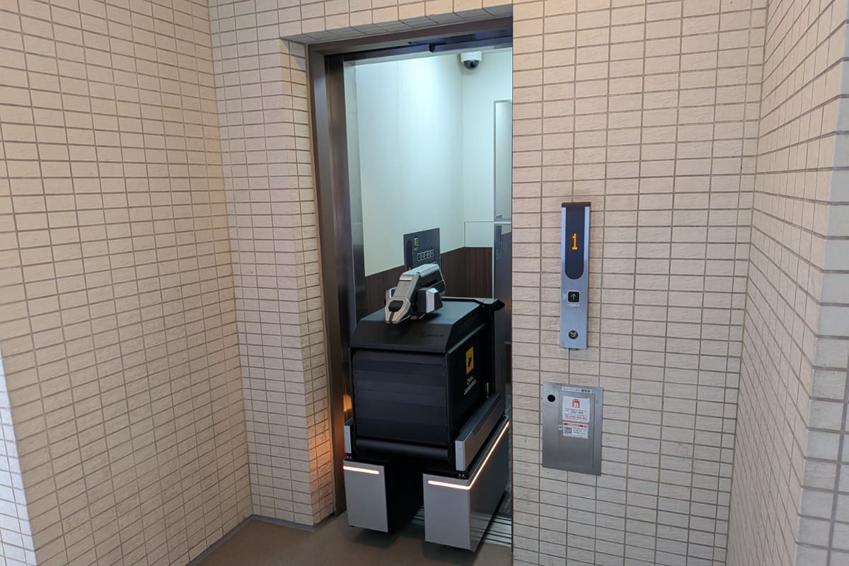 エレベーターのボタンを押して乗り込む様子