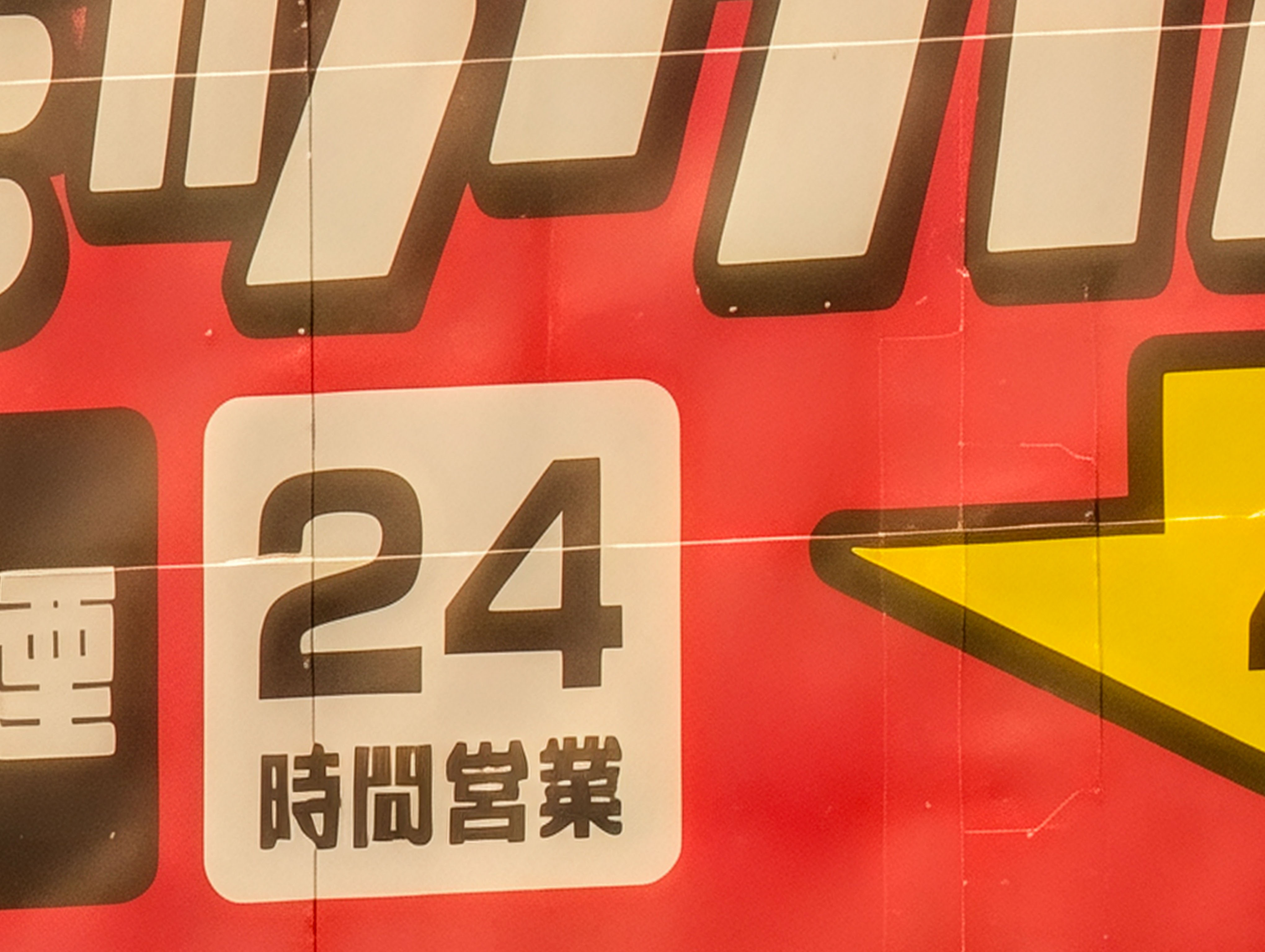 屋外の看板を100倍ズーム。超解像ズーム Proを使うと「時間」「営業」といった細い文字に違和感が