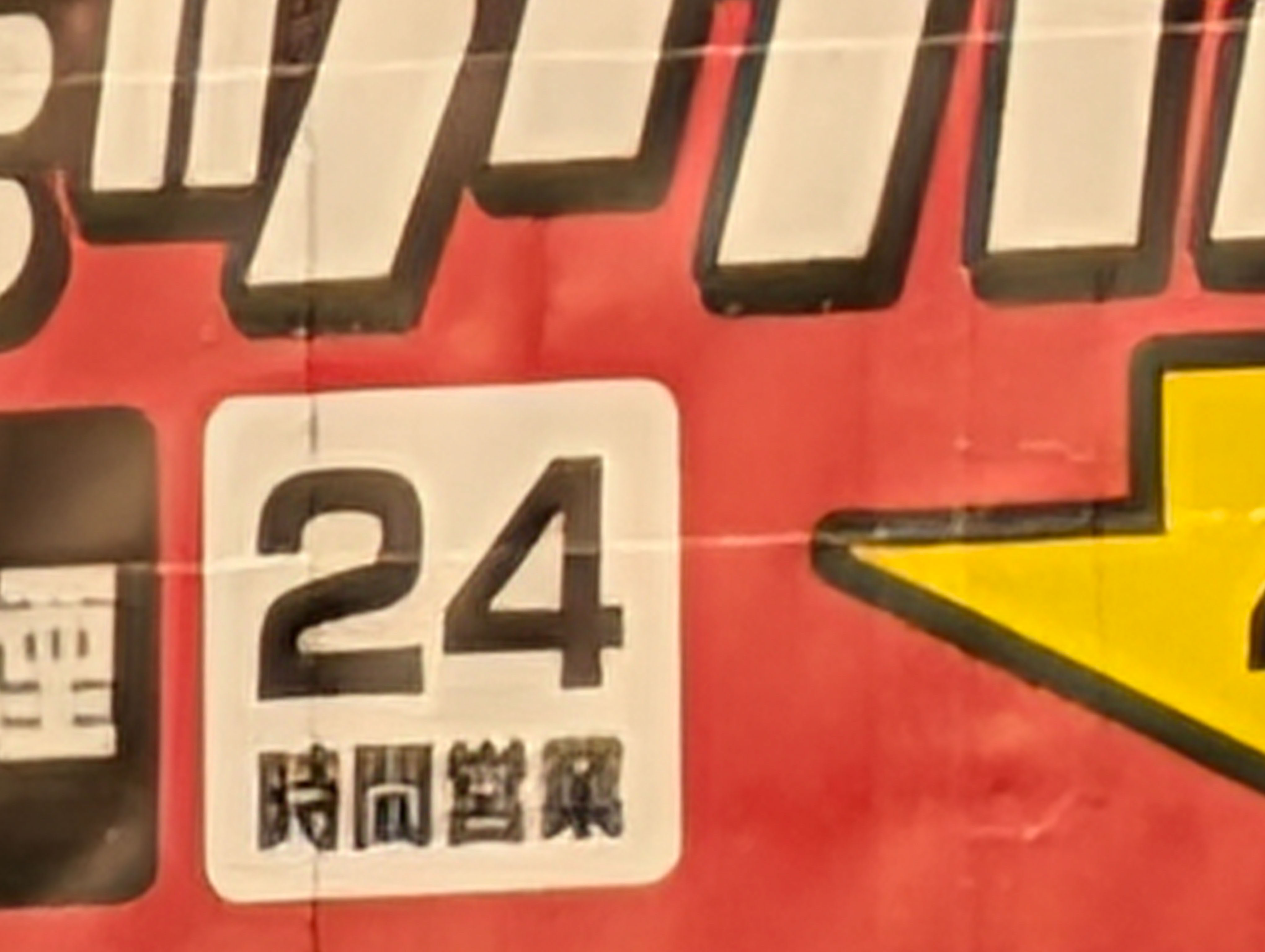 屋外の看板を100倍ズーム。超解像ズーム Proを使うと「時間」「営業」といった細い文字に違和感が