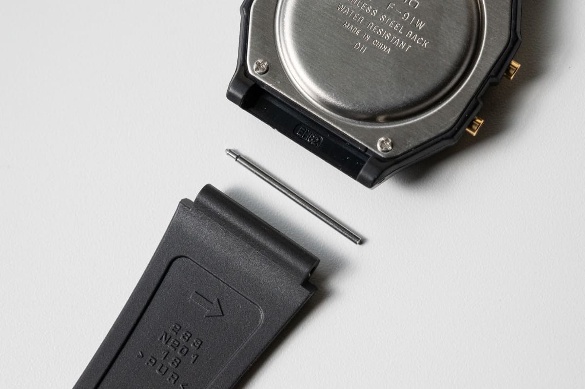 コスト削減のためバネ棒ではなく圧入ピンを採用。バンド裏側には圧入ピンを抜く方向が矢印で記されている　※ピンの着脱は自己責任で行なう作業