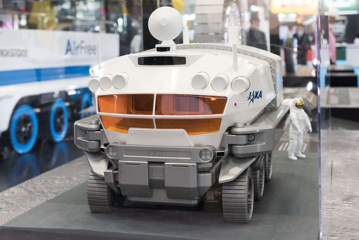 JAXA/トヨタで開発中の有人与圧ローバの模型。6輪で走行し、与圧キャビン内で宇宙飛行士は宇宙服を脱いだシャツ姿で生活できる機能を備えています。走行性能やエネルギーを供給する展開式大型の薄膜太陽電池パネルの展開実験などが地上で続いています(撮影:小林伸)