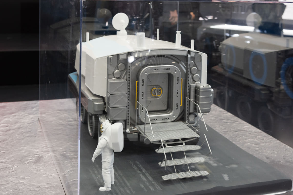JAXA/トヨタで開発中の有人与圧ローバの模型。6輪で走行し、与圧キャビン内で宇宙飛行士は宇宙服を脱いだシャツ姿で生活できる機能を備えています。走行性能やエネルギーを供給する展開式大型の薄膜太陽電池パネルの展開実験などが地上で続いています(撮影:小林伸)