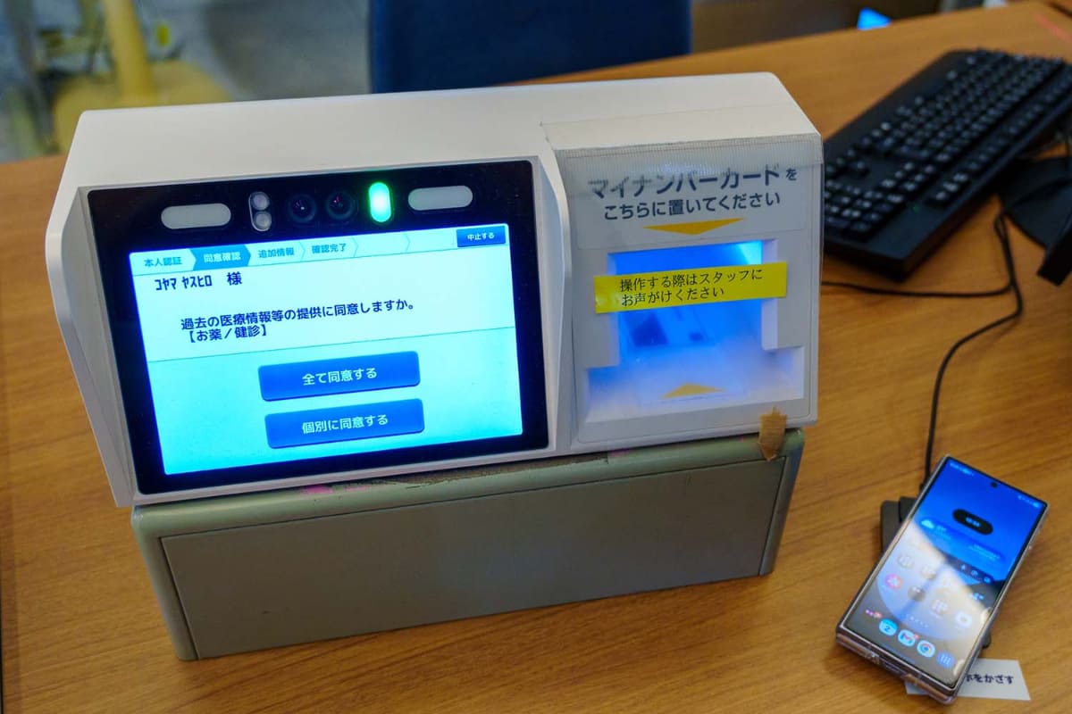 担当者は、スマートフォンのマイナ保険証によって、マイナンバーカードよりも持ち歩きのハードルが低くなり、マイナ保険証の利用率向上に繋がると期待する(写真は7月のもの)