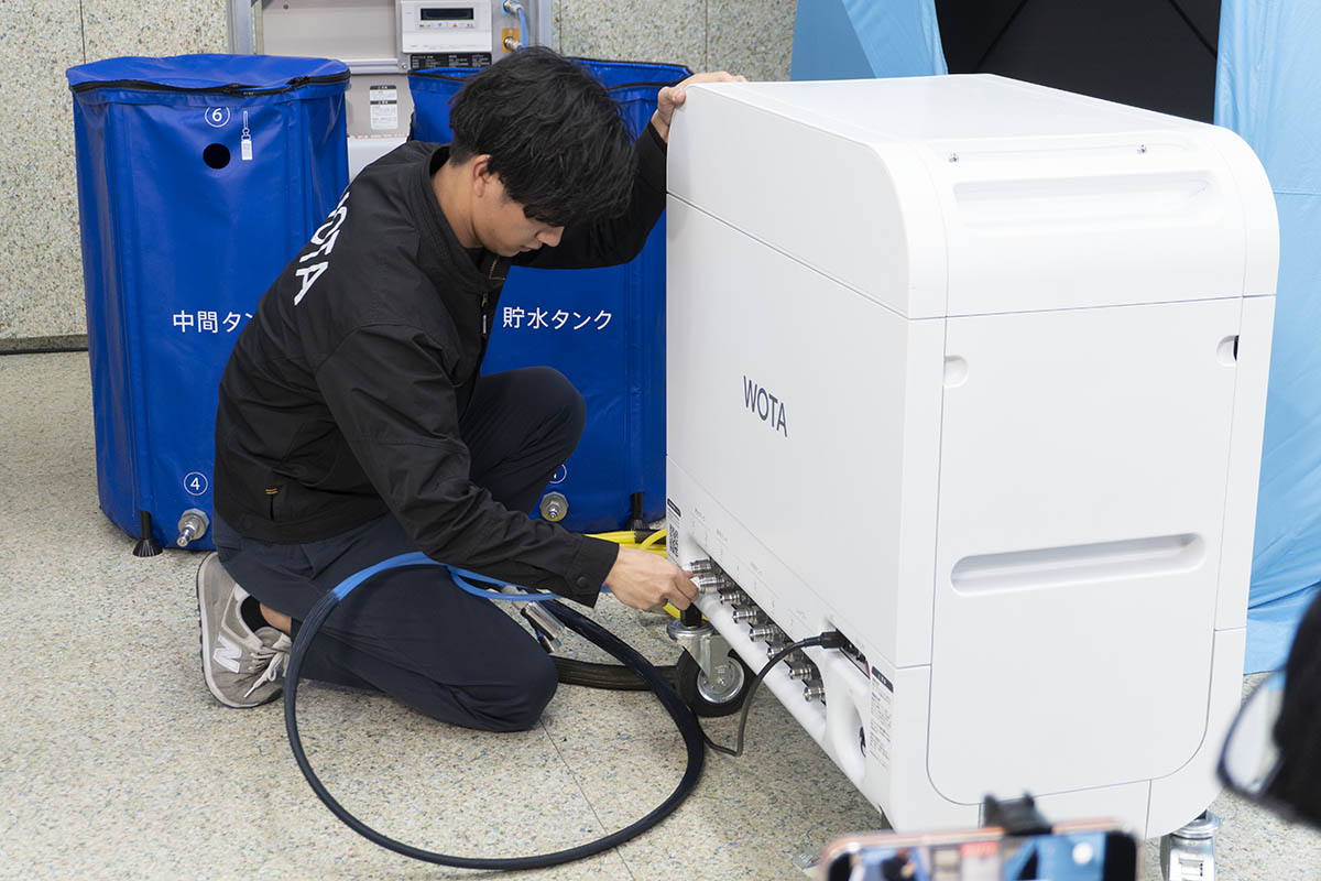 WOTA BOX、タンク、給湯器を専用の管で接続すると温水シャワーを浴びられる