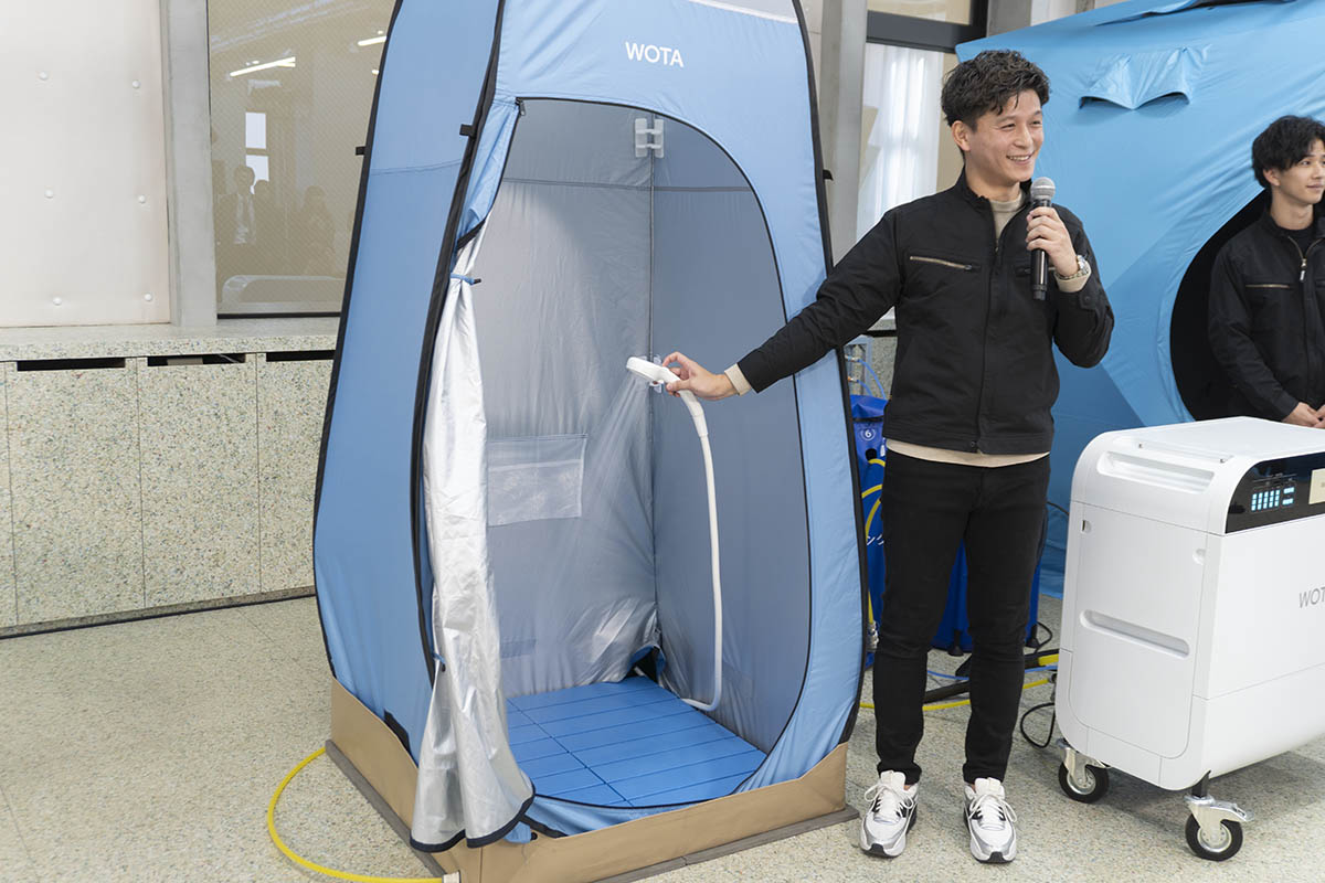 WOTA BOX、タンク、給湯器を専用の管で接続すると温水シャワーを浴びられる