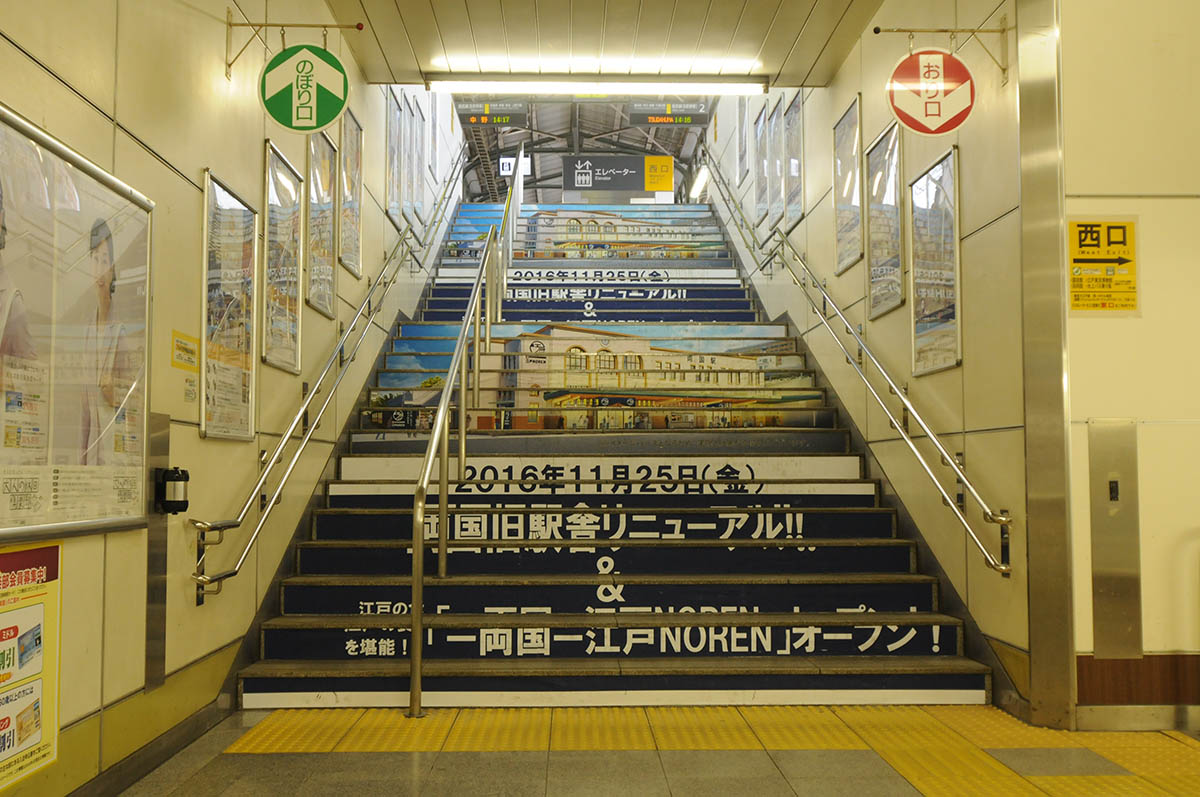 両国駅構内の階段にも江戸NORENオープンの告知が見られた(16年11月撮影)