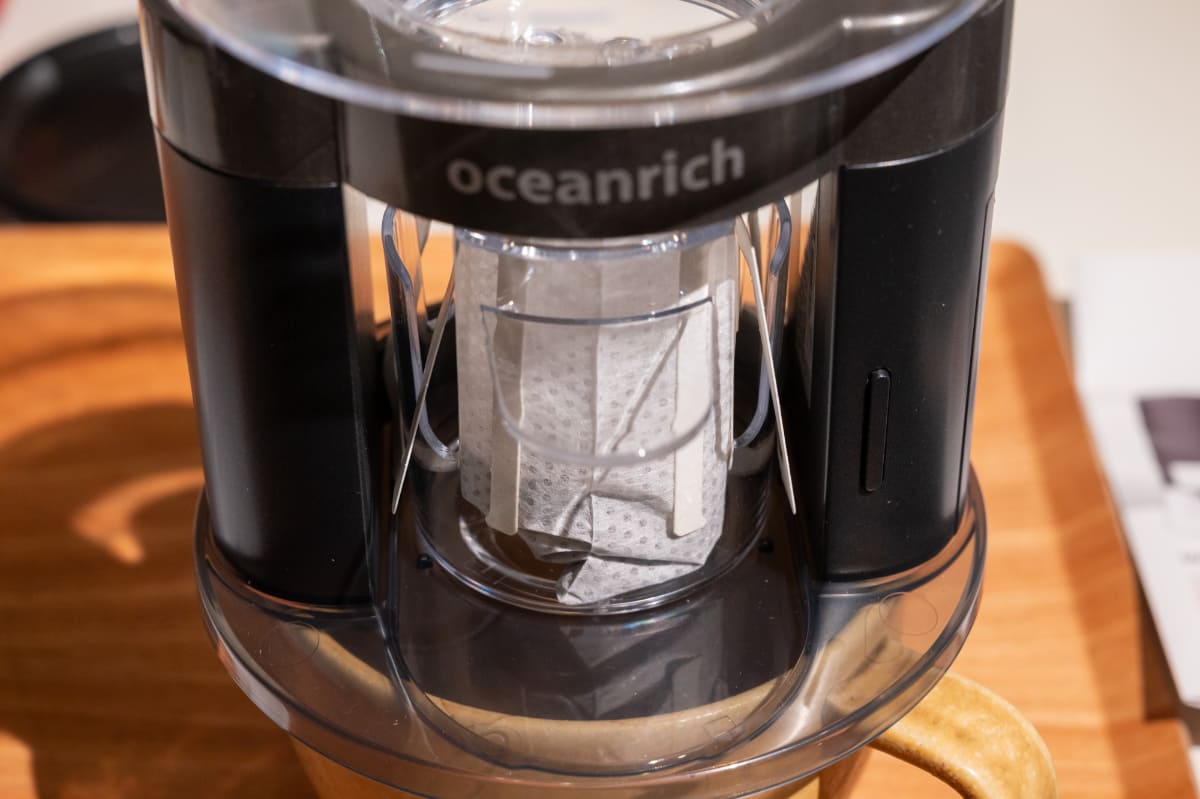 中心のホルダーにドリップバッグをセットできます。電池駆動のモーターで上のカップが回転、お湯がゆっくりと注がれる仕組みです