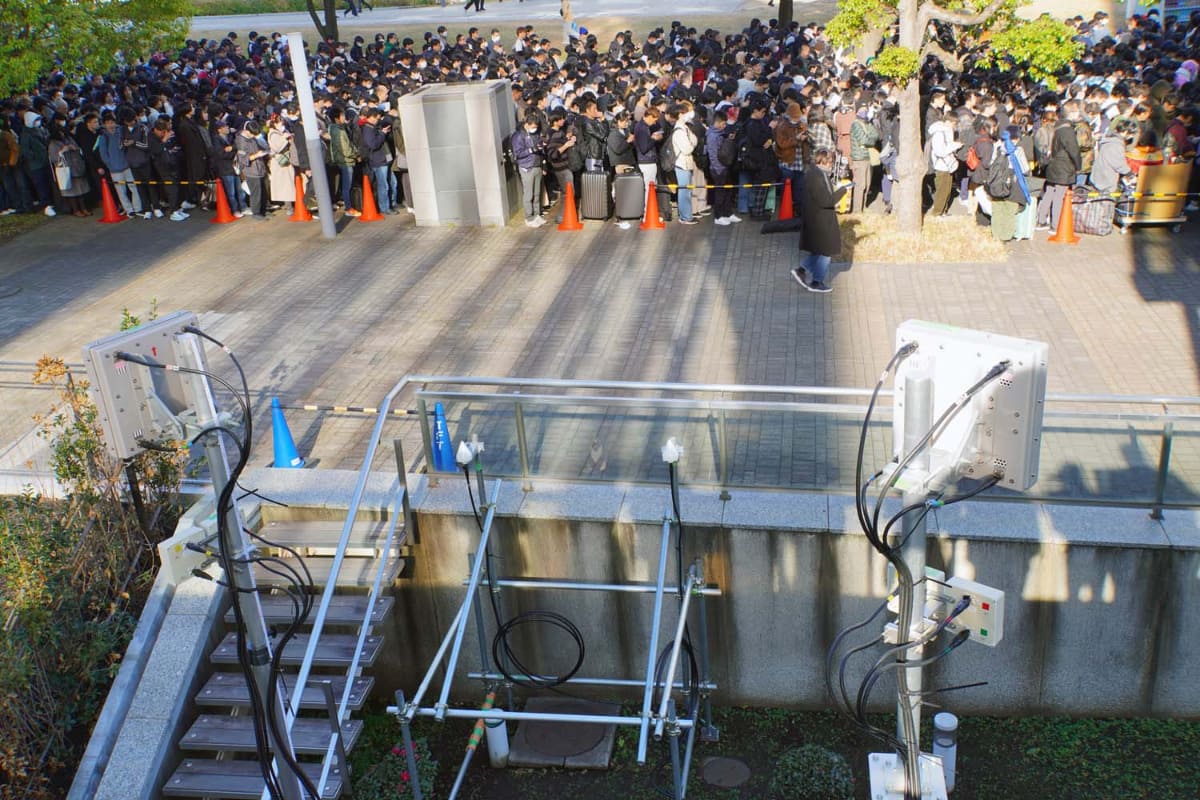 25年末に開催されたコミケに合わせ、ドコモはネットワーク対策を公開した。写真は西待機列に並ぶ人と、ドコモの臨時基地局