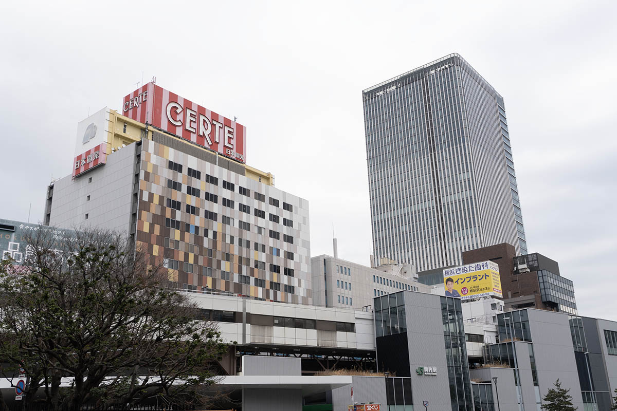 今後の再開発予定エリア(写真左)とBASEGATE横浜関内(写真右)。手前はJR関内駅