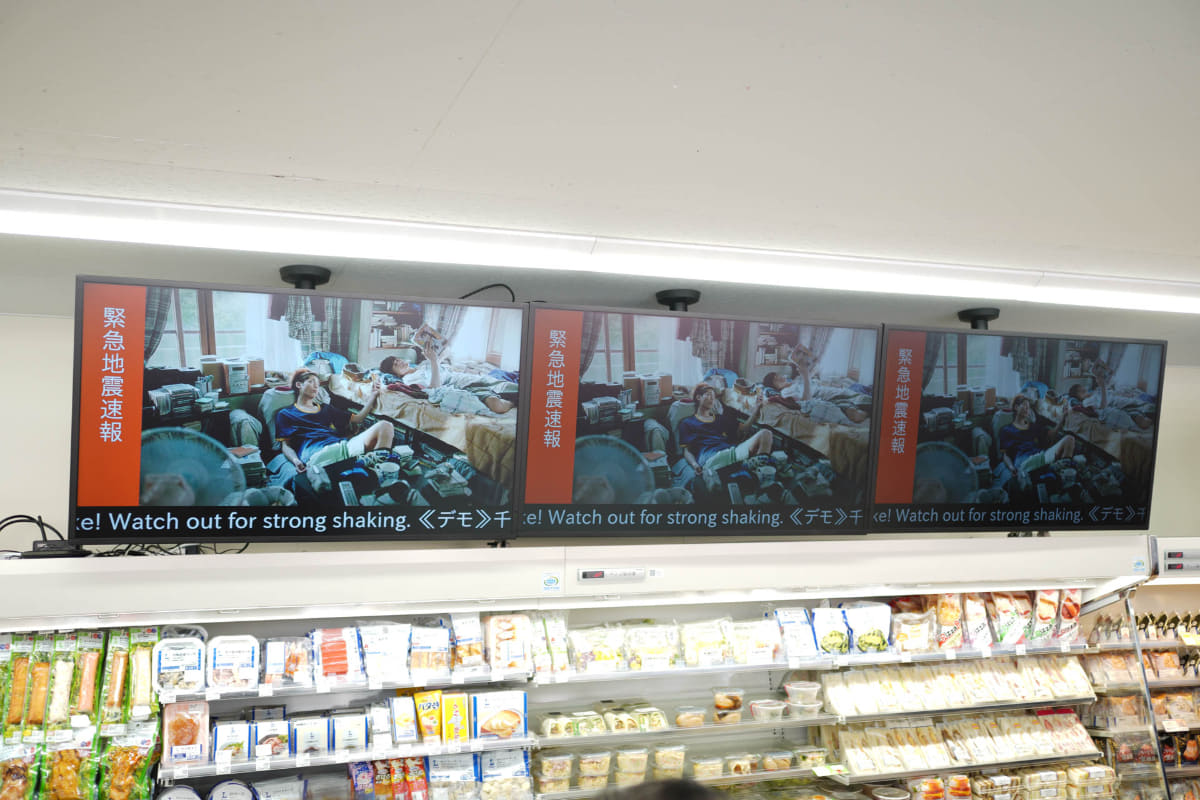 緊急地震速報を表示するデジタルサイネージ。本来の映像も残してのL字表示だが、緊急速報はエヴァみたいな極太明朝で画面全体を占有しても良い気はする