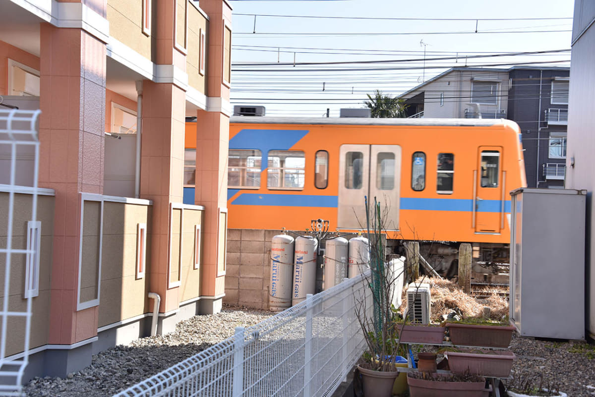新坂川に沿った道路から線路側に視線を向けると、住宅と住宅の間から流鉄の電車を見ることができる