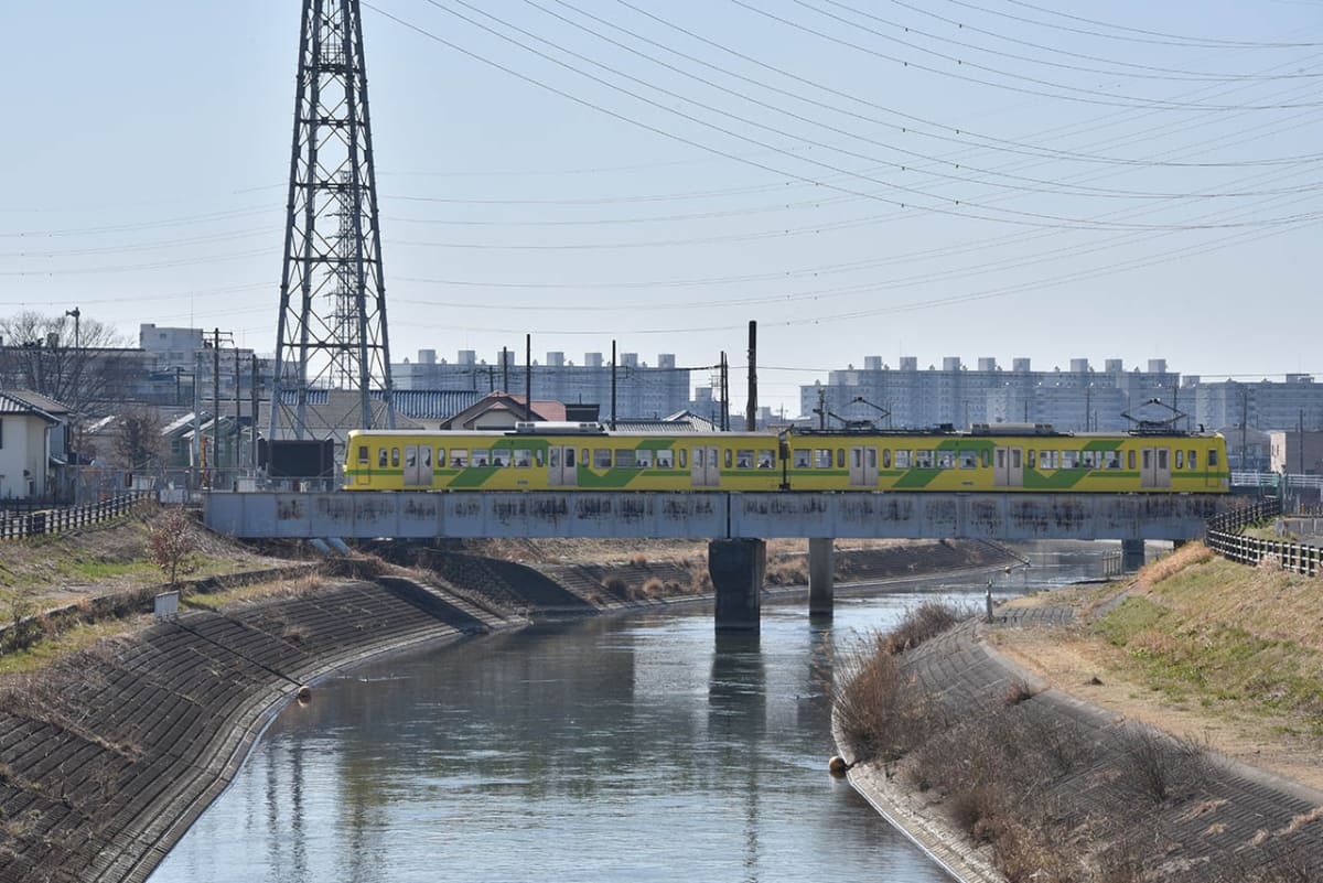 新坂川の本流・坂川の鉄橋を渡る流鉄の電車。坂川を境に、写真右側が流山市