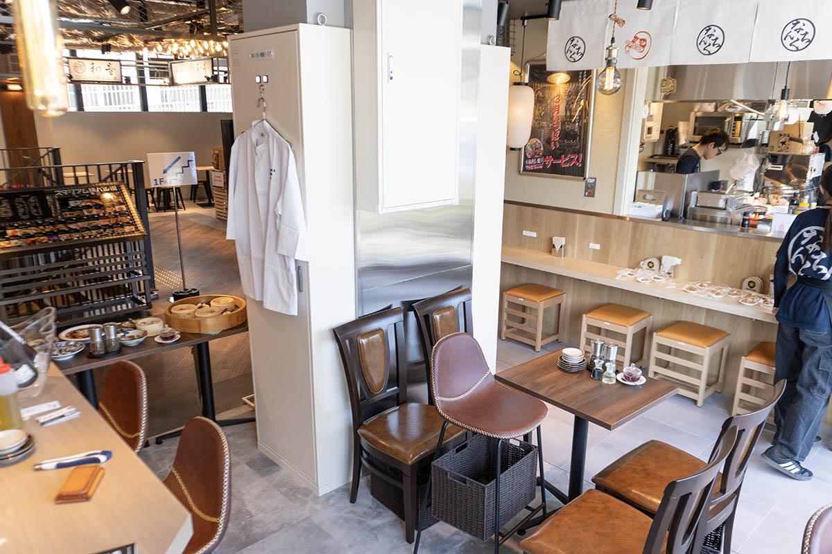 両店の客席の間には仕切りがない。写真手前のカウンターが華那、奥がなんちく、真ん中の濃いブラウンの椅子のテーブル席は華那