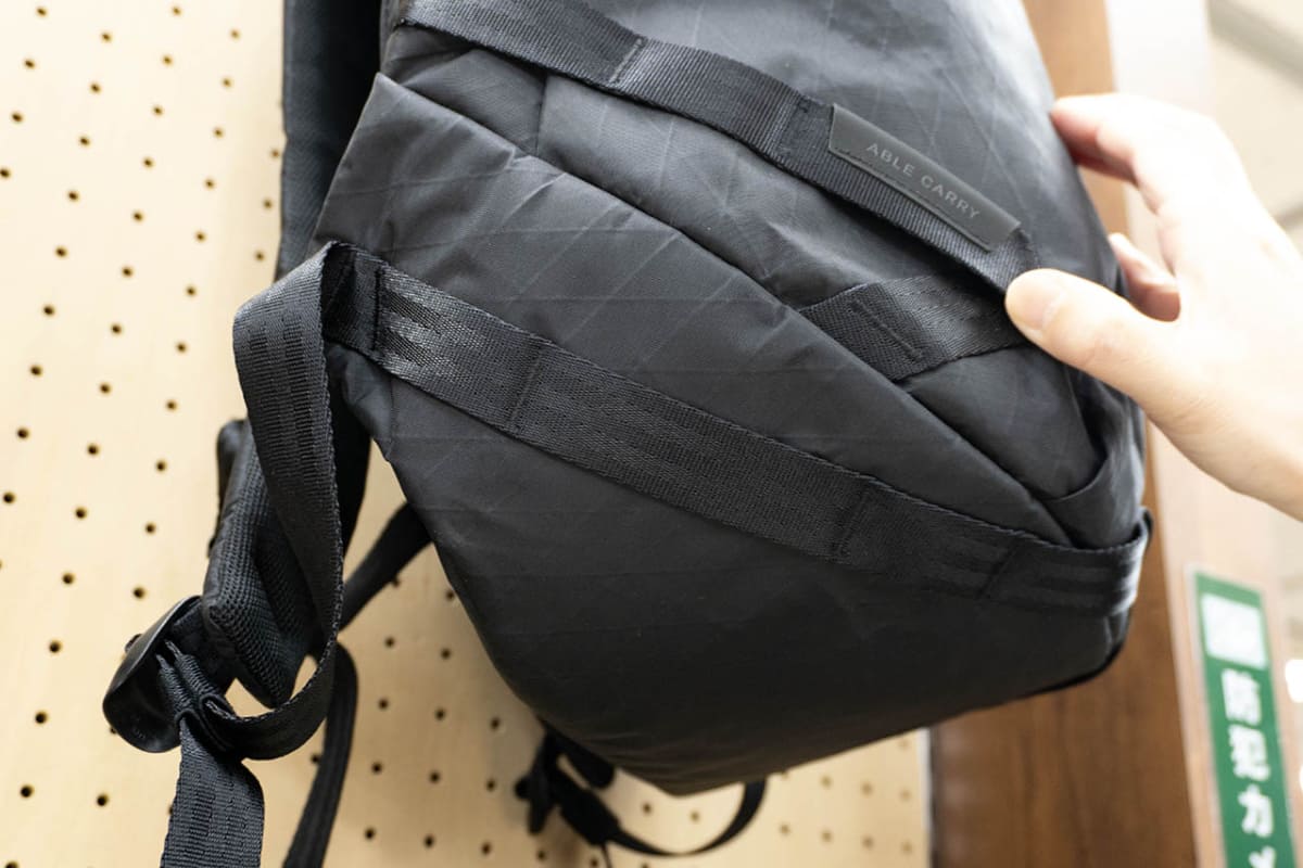 バックパックの底面まで伸ばしたストラップが荷物の重量を下から支える