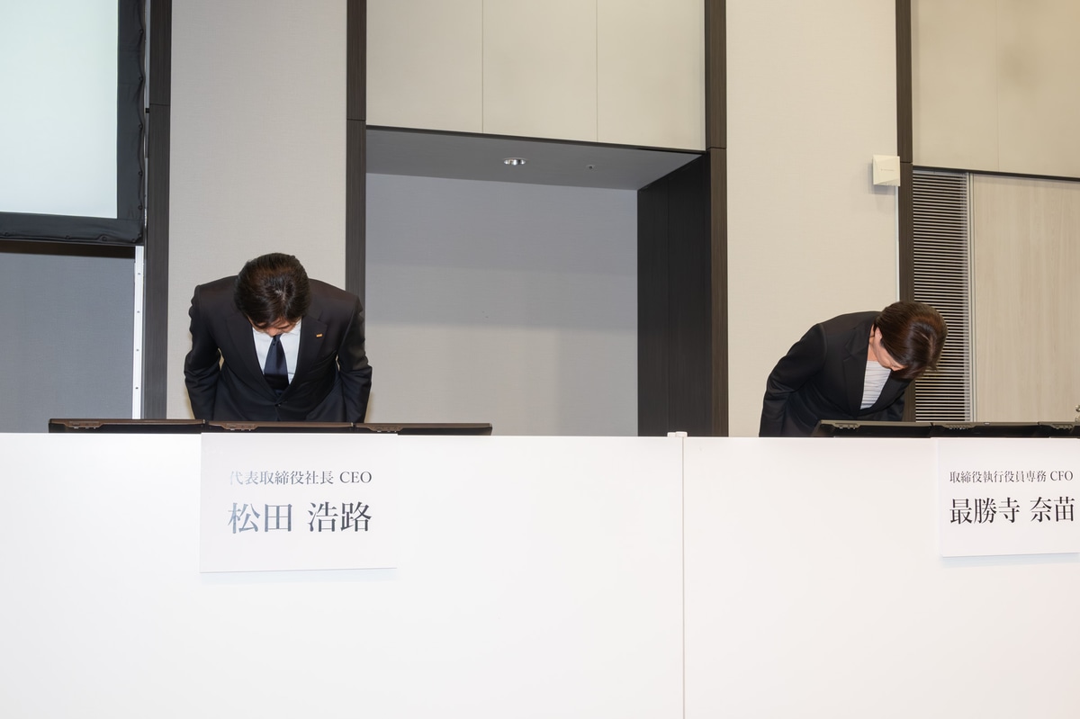 会見の冒頭で頭を下げるKDDI松田社長とCFOの最勝寺奈苗氏