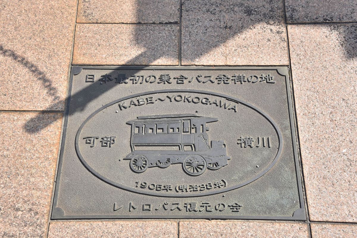 可部駅前の地面には乗合バス発祥レリーフが埋め込まれている
