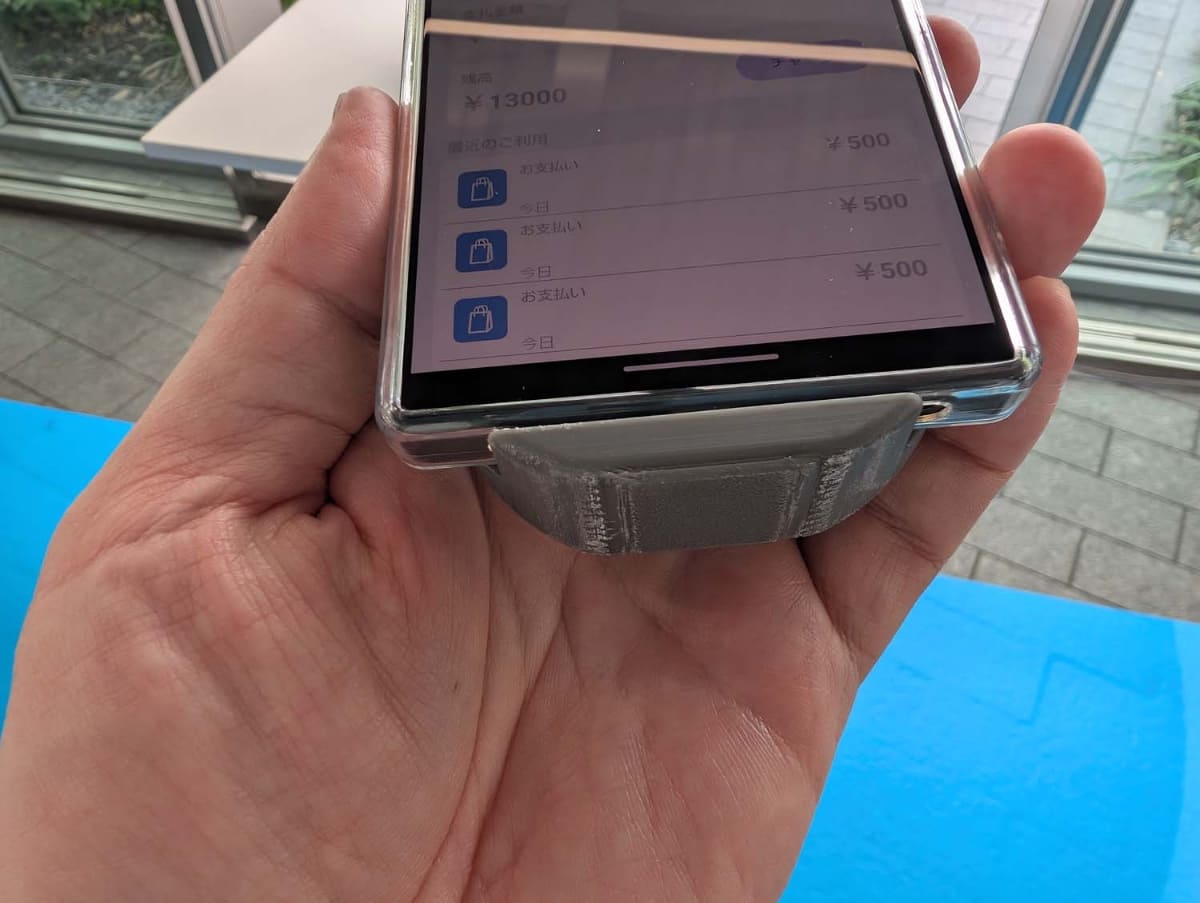 未来の決済体験デモで用いられたシャープのAQUOSスマートフォン。機種的にはウォークスルー改札のデモで用いられていたのと同じもの。こちらにはマルチアンテナモジュールが取り付けられていた