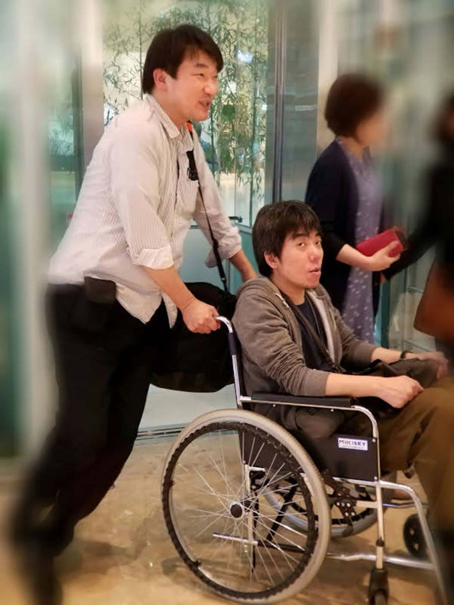 いろいろと海外でのトラブルに遭遇していますが、医療関連だと一度だけ、取材旅行中に急に足を痛めたことがあります。これは韓国で、同行した某氏に車椅子を押してもらっているところです
