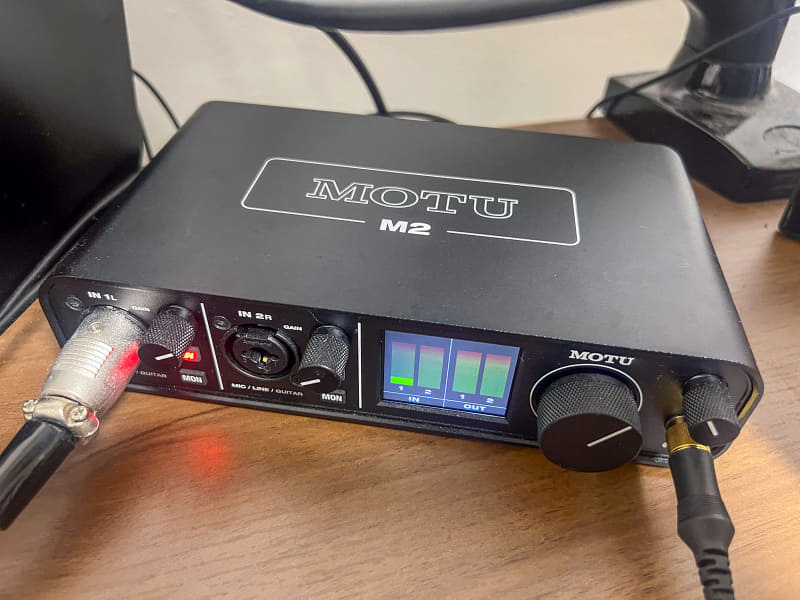 筆者が愛用しているオーディオインターフェイス、MOTU「M2」。オーディオテクニカのコンデンサーマイク「AT2020」と、ヤマハのヘッドホン「HPH-MT8」が接続されている