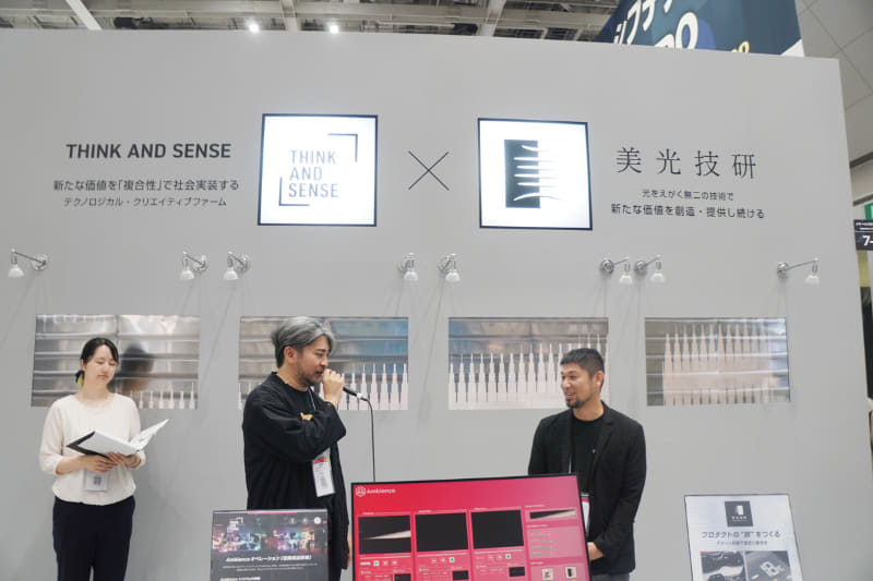 ティーアンドエスと美光技研のコラボによる展示。人間の顔ほどの高さにある銀色のパネルが美光技研による金属板で、その背後のディスプレイで映した映像が透けている。なお場面は後述のトークショー