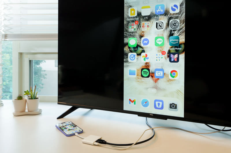 iPhoneの画面をテレビにミラーリングしてみる。HDMIケーブル経由で、iPhoneの画面をそのまま大きく映すことができる	iPhoneのホーム画面をテレビにミラーリングした状態