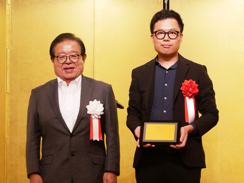 村井純審査委員長（左）と大賞を受賞したSkyDriveの福澤知浩社長（右）