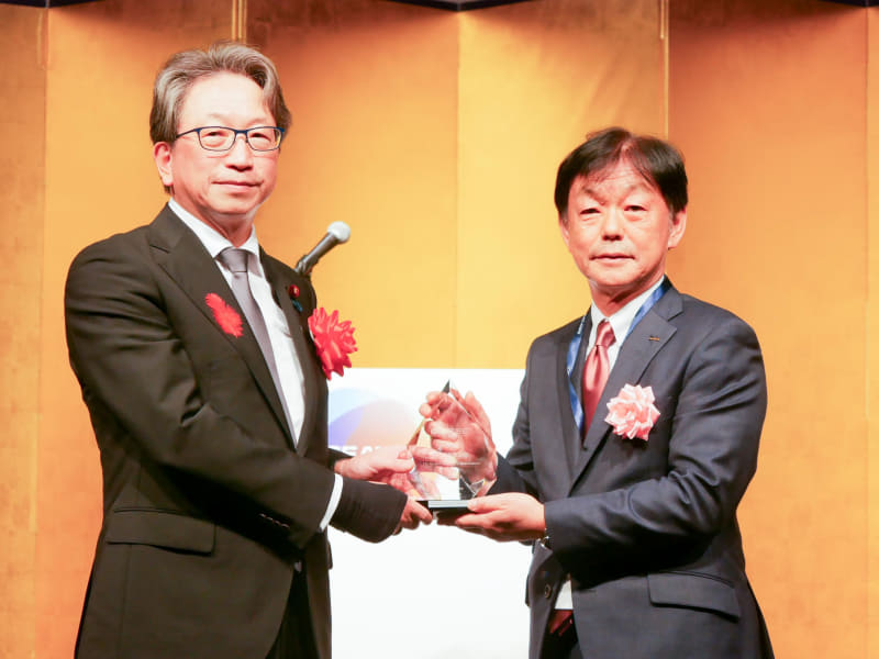 デジタル庁の平将明大臣からデジタル大臣賞のトロフィーを受け取る村田製作所の中島規巨社長