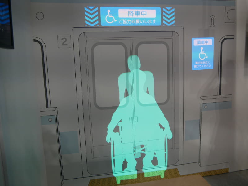 ホームに設置した「Omject」で、電車にメッセージを投影し、車いすの人が降車することを通知し、通路を確保できるように促す