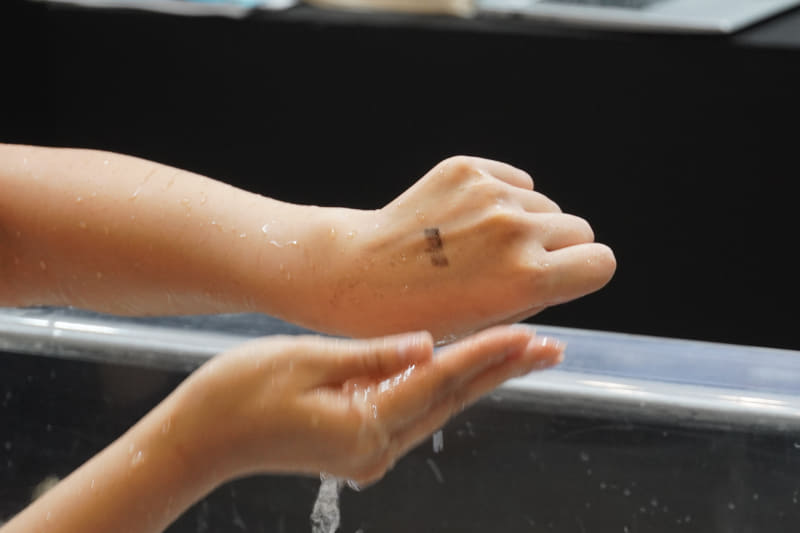 洗剤なしでここまで落ちた。ちなみにモデルさんは今日2回目のデモのため、最初のデモで皮脂が落ちてしまい、その状態で油性ペンを塗ったため、汚れは落ちにくい状態。1回目ならもっと落ちたという