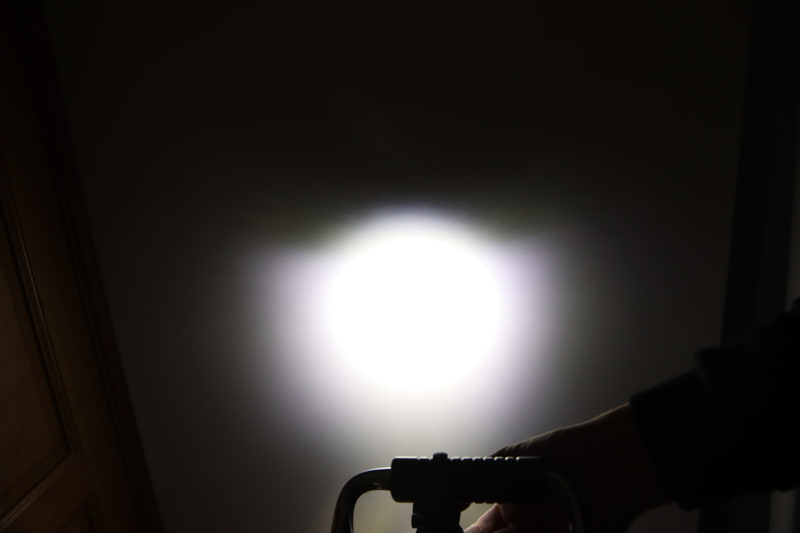 RN1200の光の形。丸い光の上側がシェードの影でカットされ、代わりに下側にシェードで反射された光が広がる