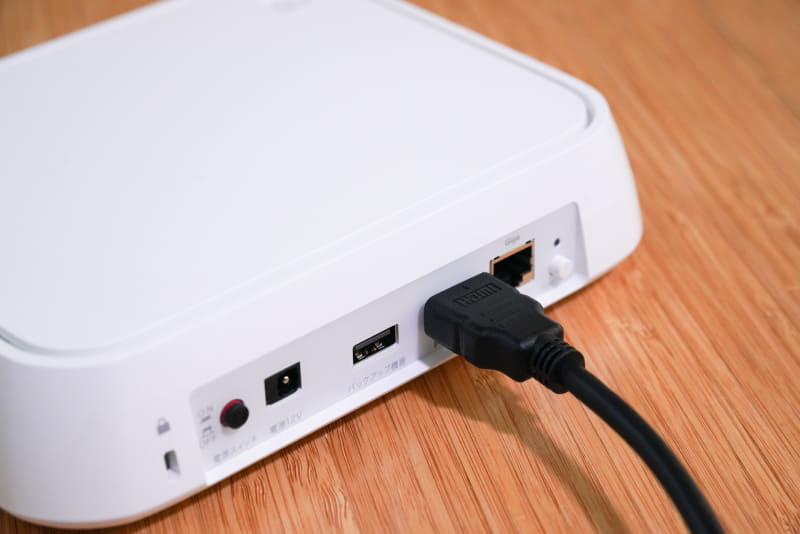 「おもいでばこ」の背面。ACアダプター接続ポート近くにあるスイッチを押し込んでオンにする