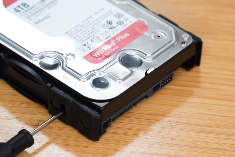 HDDをトレイにネジ留めする。向きには注意して、コネクターが露出するように装着する