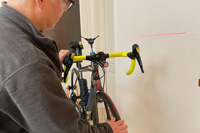 ロードバイクの正面からレーザーを当てると、スタンドでは垂直になっていないことや、ハンドル（ステム）が若干曲がっていることが発覚した