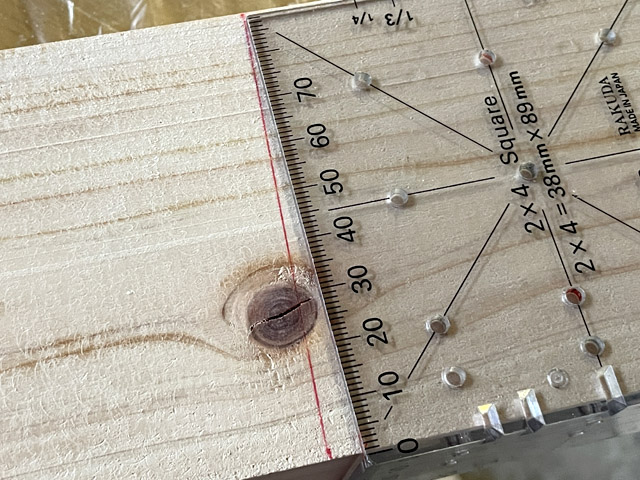 定規が板に対し直角。赤線にあわせ斜めにカット
