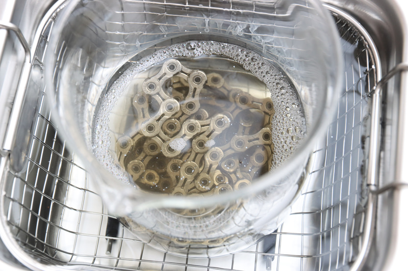 洗浄液にチェーンを漬けて2分ほど。すでに洗浄液に色が付き始めている