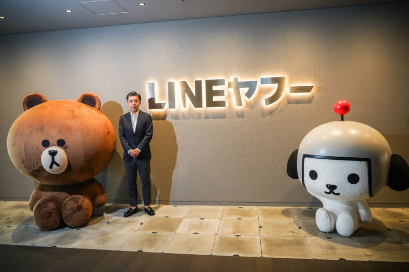 LINEヤフー株式会社 上級執行役員 メディア・検索ドメイン AI Agent統括SBU リード 葭沢光伸氏。左はブラウン（LINE FRIENDSのキャラクター）、右はけんさく（ヤフー公式キャラクター）