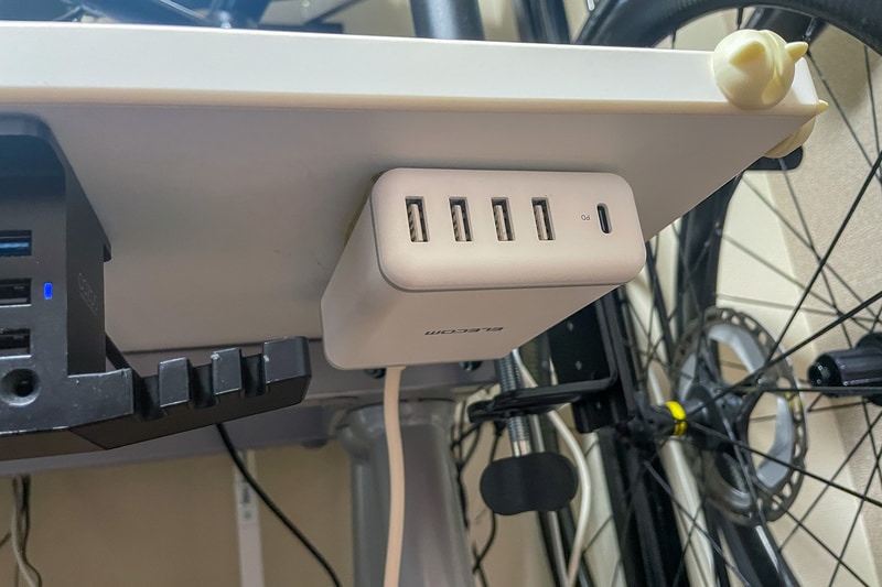 デスクの下に両面テープで貼り付けたエレコムの充電器。椅子に座ったまま片手で抜き差しできるのでとても便利だった……