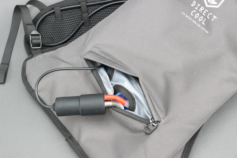 下のファスナーを開けると中に電動ポンプ。赤いほうがビニールバッグに、コイル巻きのほうが冷却用ホースに繋がる