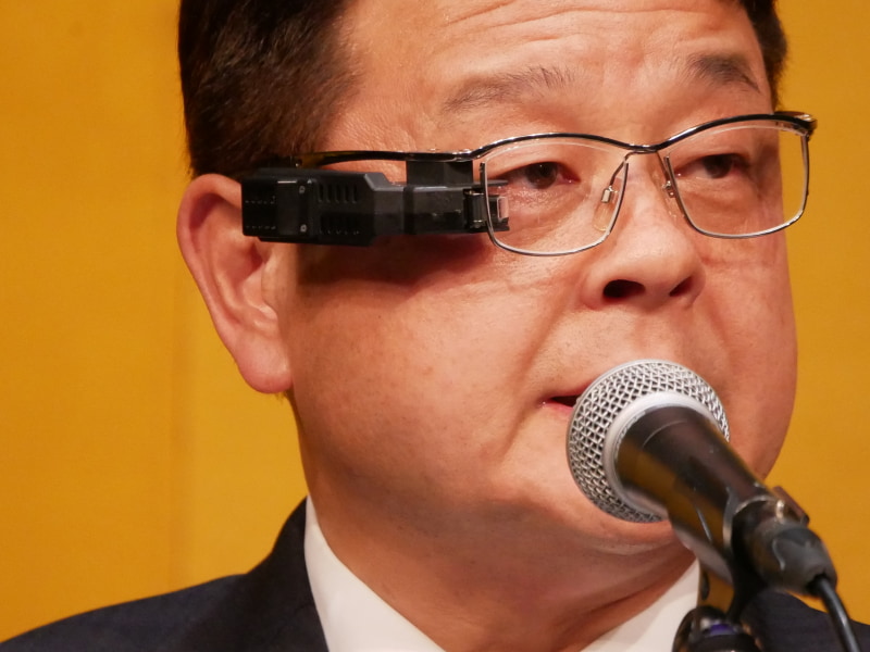 若山経済産業大臣政務官は、「スマートグラス用ディスプレイ向けメタオプティクスミラー」を着用して表彰を行った