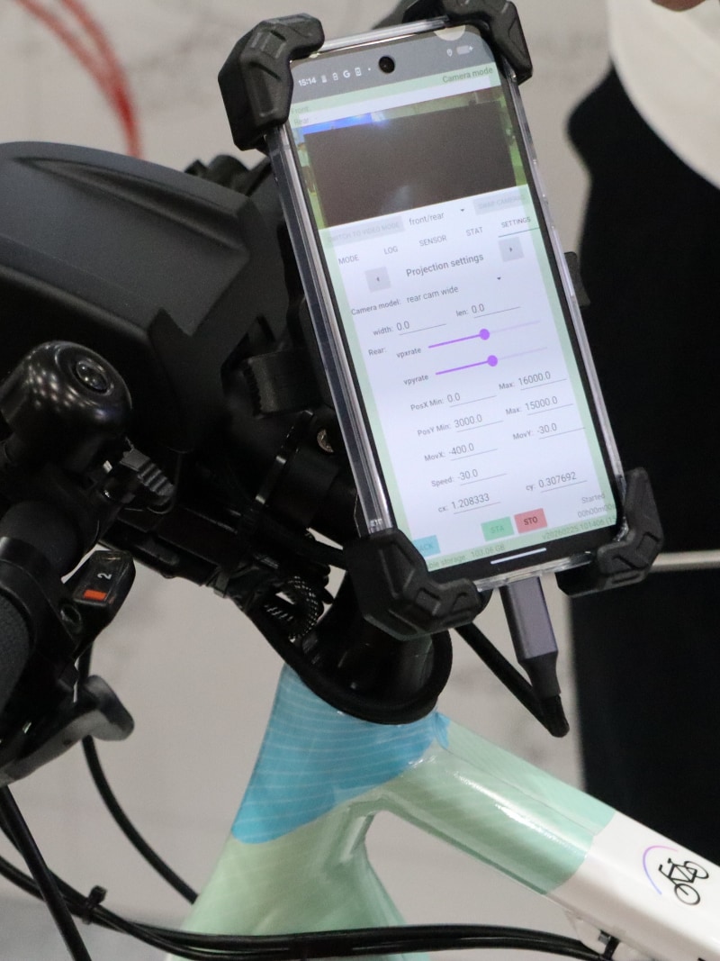 自転車やバイクに後付けできるカメラから入力される周囲の映像をもとに、CI（Cooperative Intelligence：協調人工知能）がリスクを予測し、スマートフォンでアラートを出す仕組み